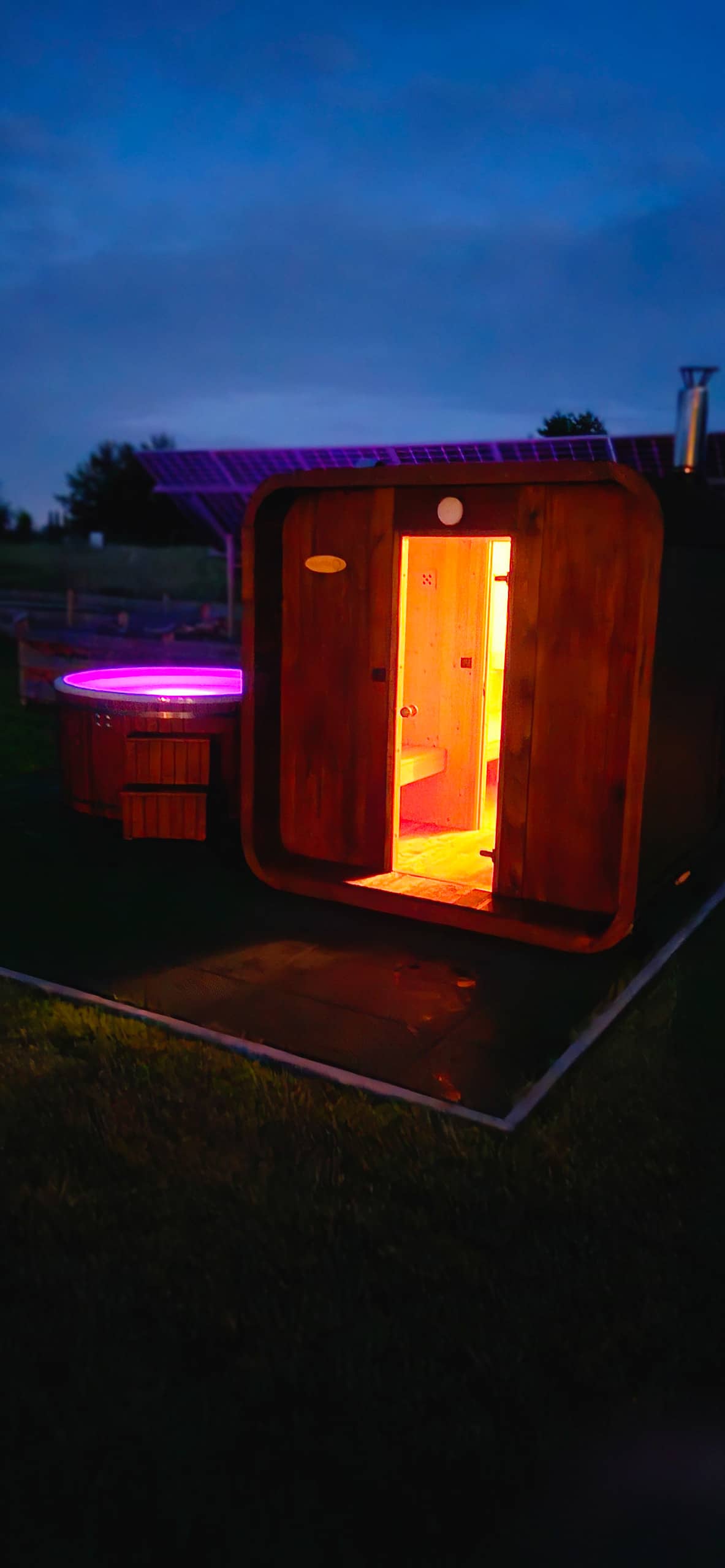 Sauna o zmierzchu — rozżarzone wnętrze, para nad jeziorem